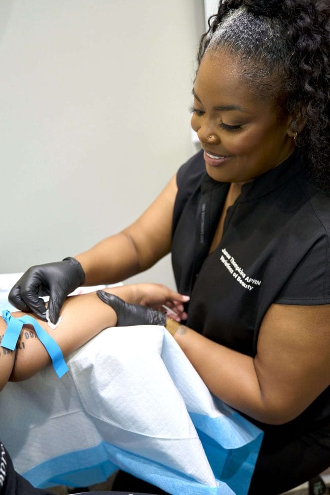 Janae Thompkins APRN administering an IV vitamin drip