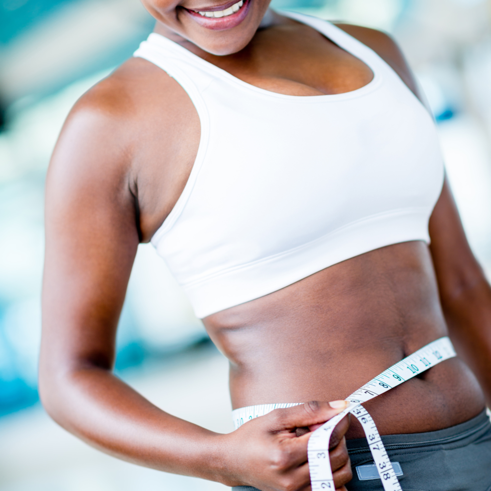 Woman measuring her waist after medical weight loss treatment
